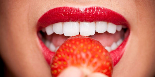 Primer plano de labios femeninos sensuales mordiendo una fresa, representando placer y deseo