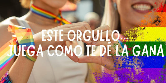 Celebración del Orgullo LGTBIQ+: dos mujeres forman un corazón con sus manos, con pulseras de la bandera arcoíris, representando el amor y el placer sin etiquetas.